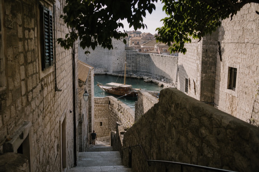 A wooden boat moored in a small harbour beside stone quays