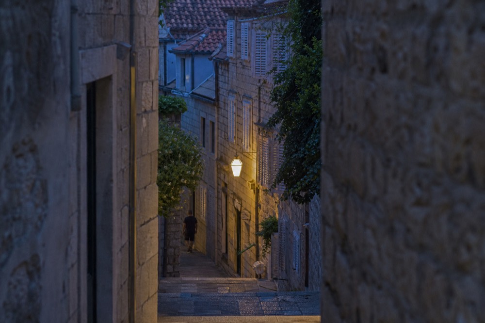 A narrow stone lane between shuttered old houses