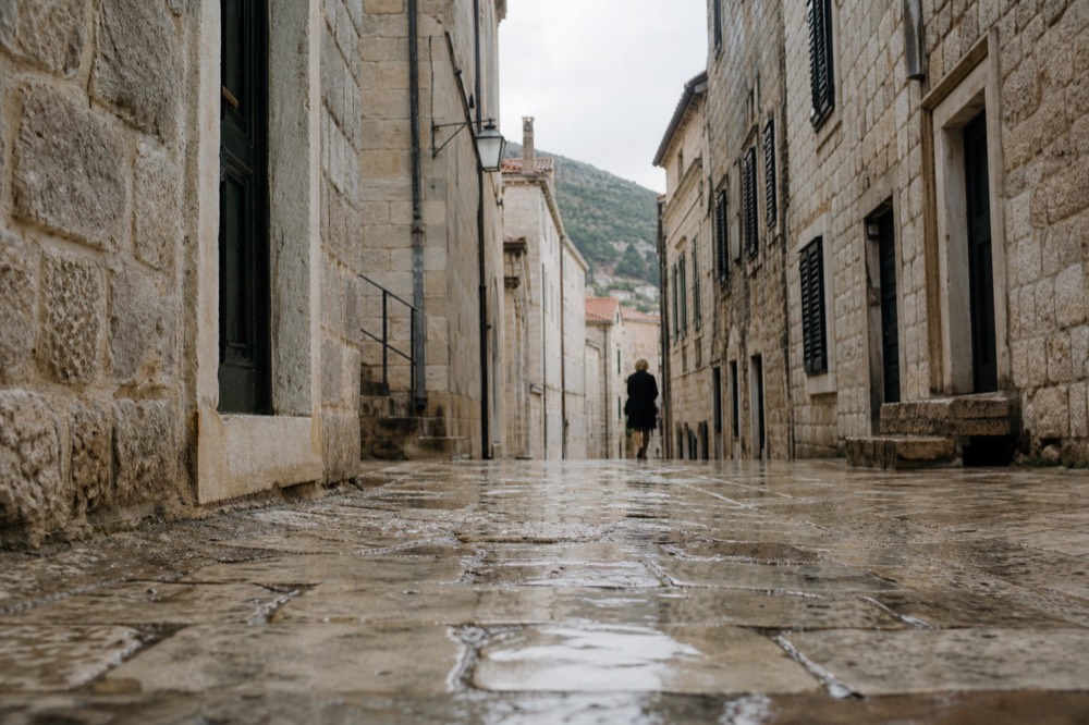 Limestone street in a walled Adriatic old town with shutters and stone staircases
