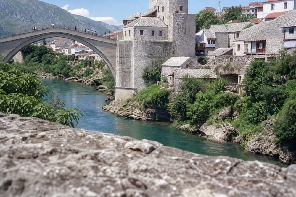 Old stone bridge arching over a river in a Balkan town