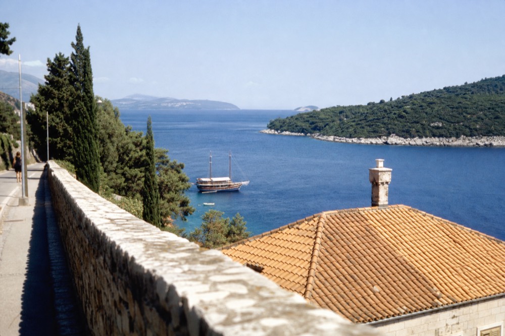 A wooden boat anchored in a calm bay between green islands