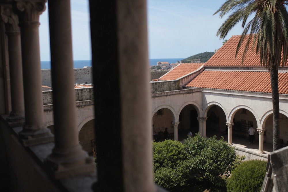 Carved stone pillars of a monastery cloister enclosing a quiet courtyard