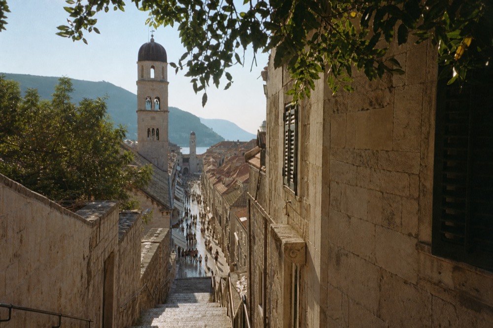 The limestone Stradun street stretching toward the clock tower in late afternoon light