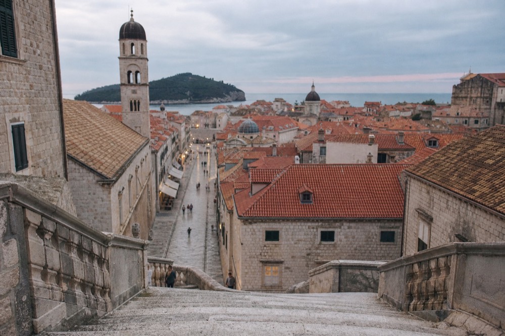 The stone Jesuit staircase descending toward the Stradun in soft evening light