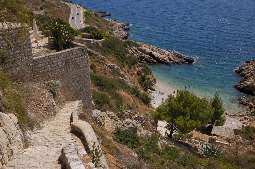 A coastal road winding above the blue Adriatic with dry hillsides