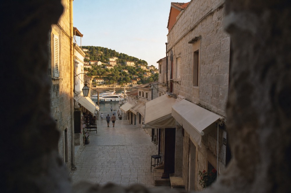 A limestone pedestrian street lined with small shop fronts and awnings