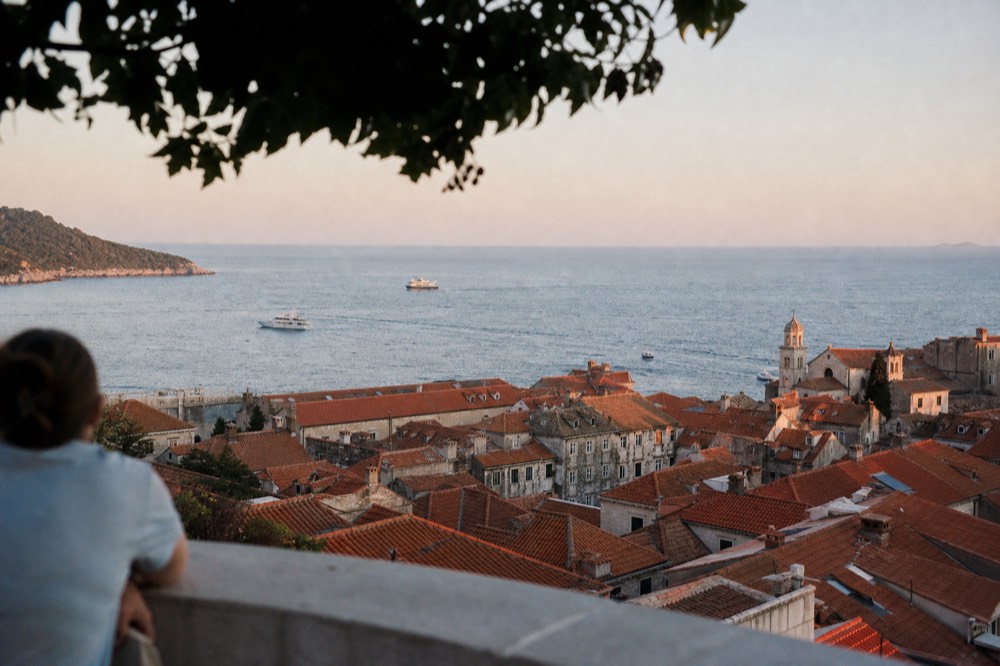 Sunset light on Dubrovnik's terracotta rooftops seen from a high stone terrace