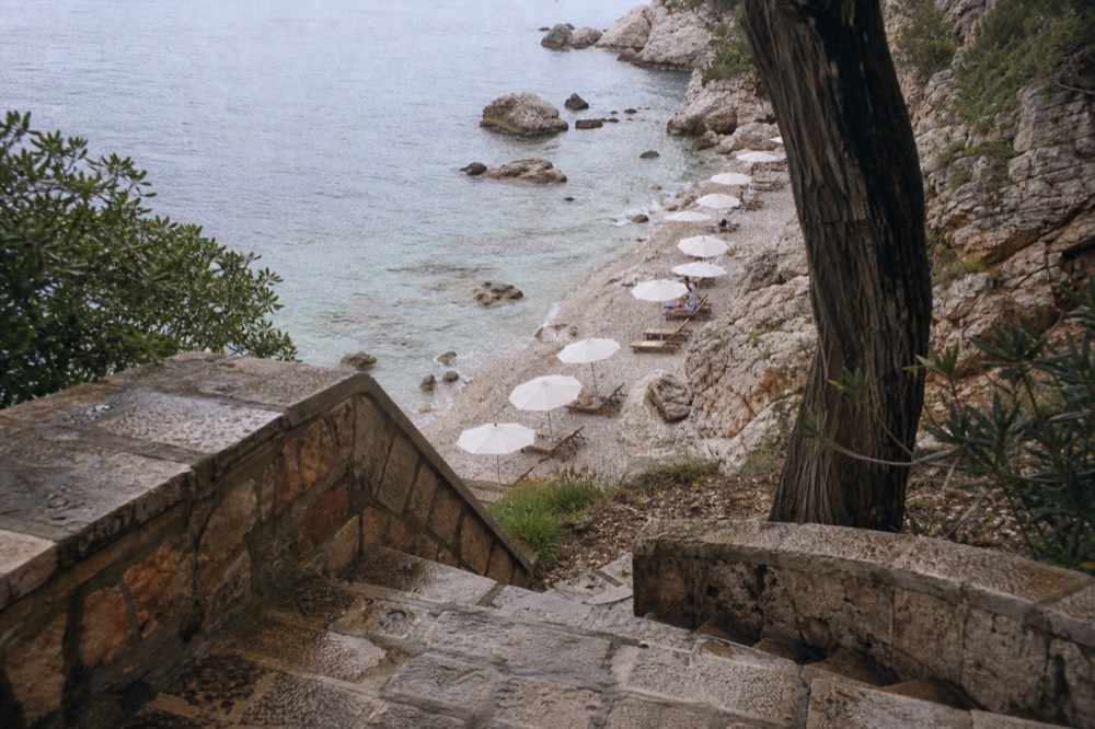 Pebble beach with clear shallow water and sun umbrellas near Dubrovnik