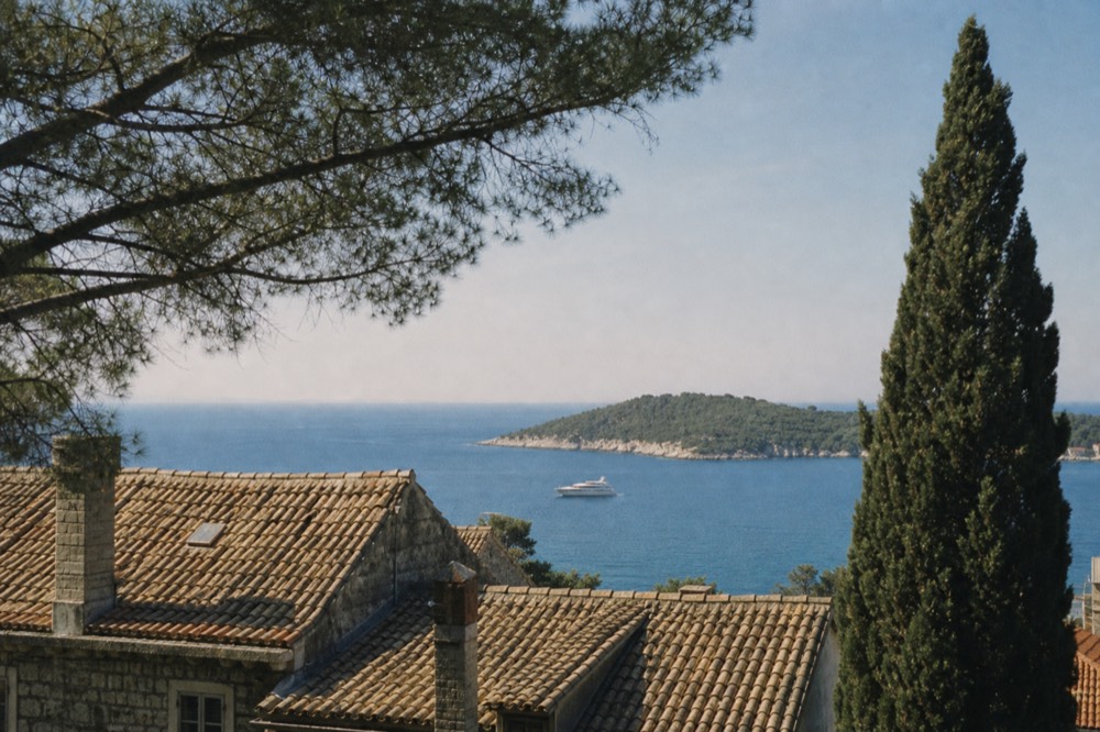 Boat anchored in clear blue water near a green Adriatic island