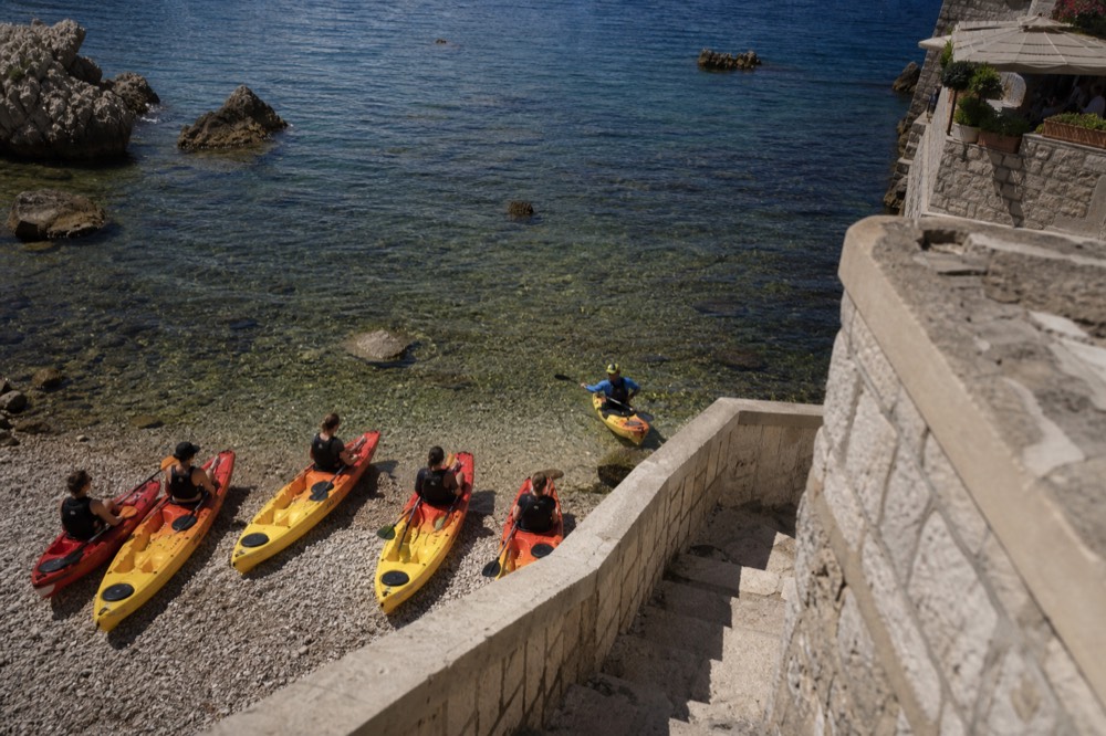Guide demonstrating paddle strokes to a small group seated in kayaks