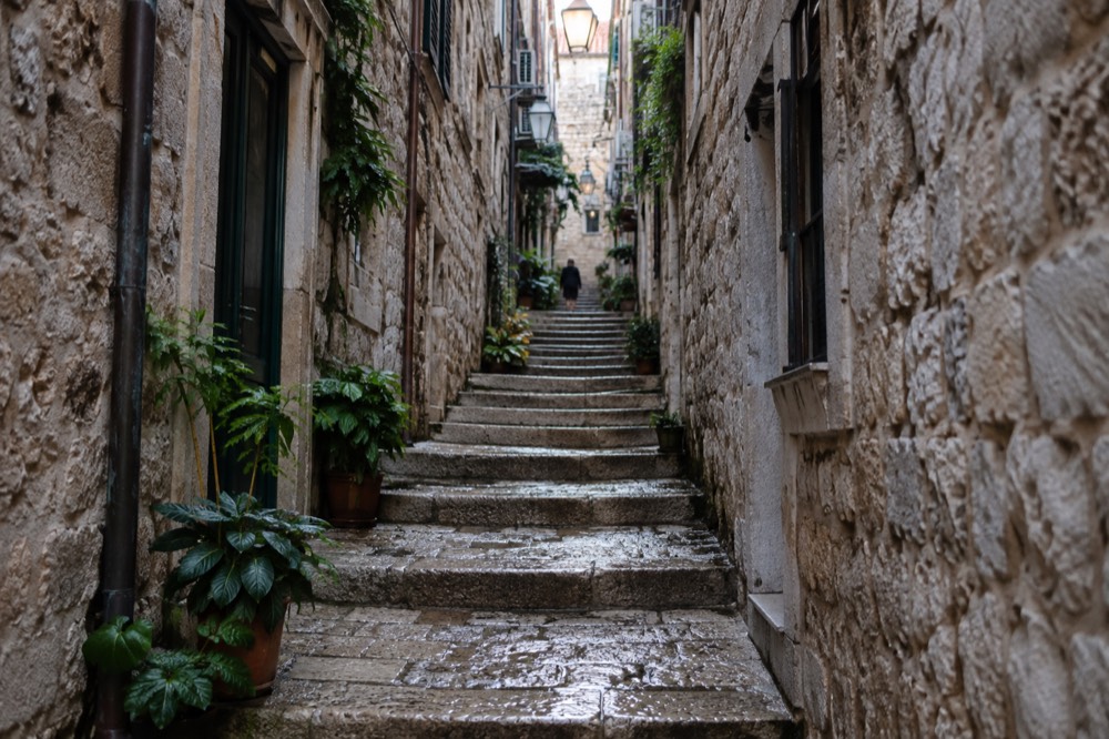 A narrow stepped alley in the Old Town, stone walls close on both sides