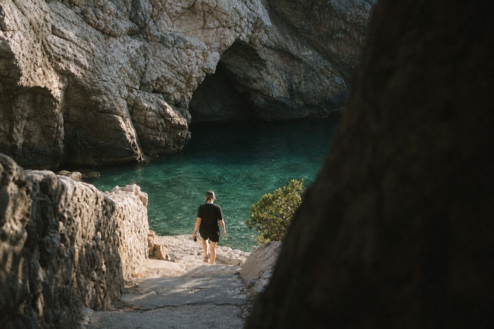 Turquoise light filling a rock grotto above still water