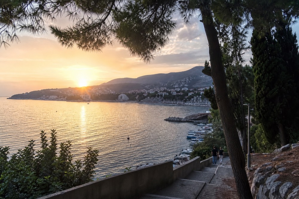Sunset over Lapad Bay with the promenade lights reflecting on the water
