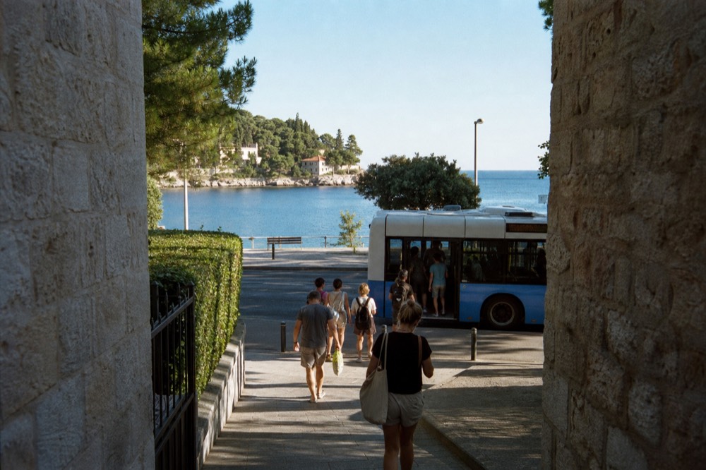 Number 6 bus pulling up at the Lapad Beach stop with passengers disembarking