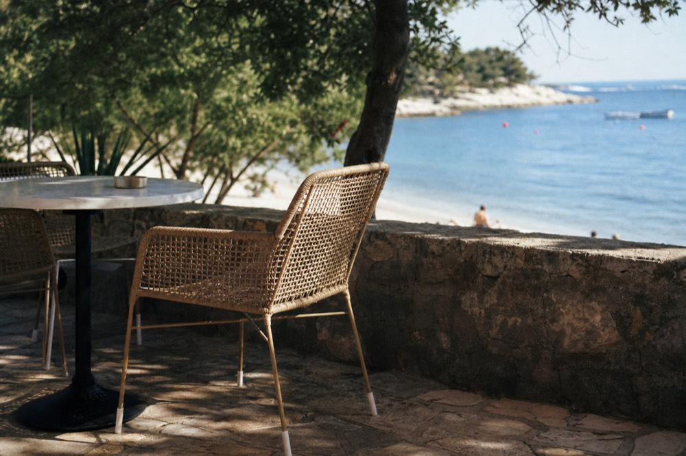 Outdoor terrace of a cafe on the Lapad Beach promenade with tables overlooking the sea