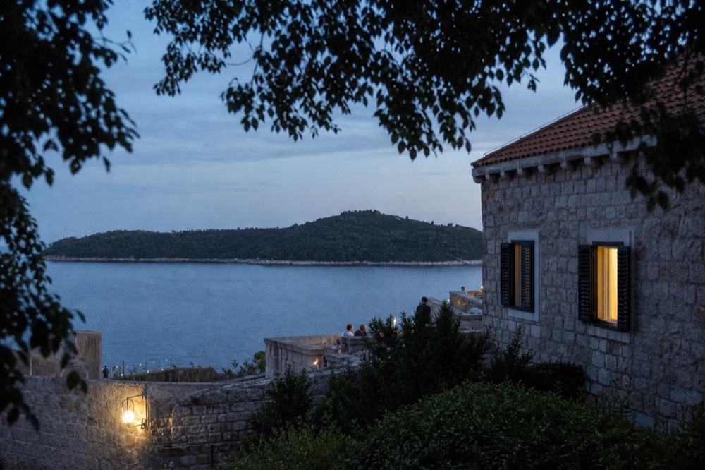 Wooded Lokrum island seen across calm blue Adriatic water from Dubrovnik harbour