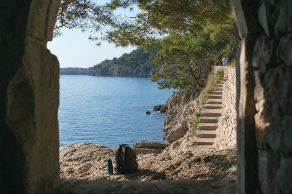 Backpack and water bottle on a rocky swimming ledge on Lokrum island