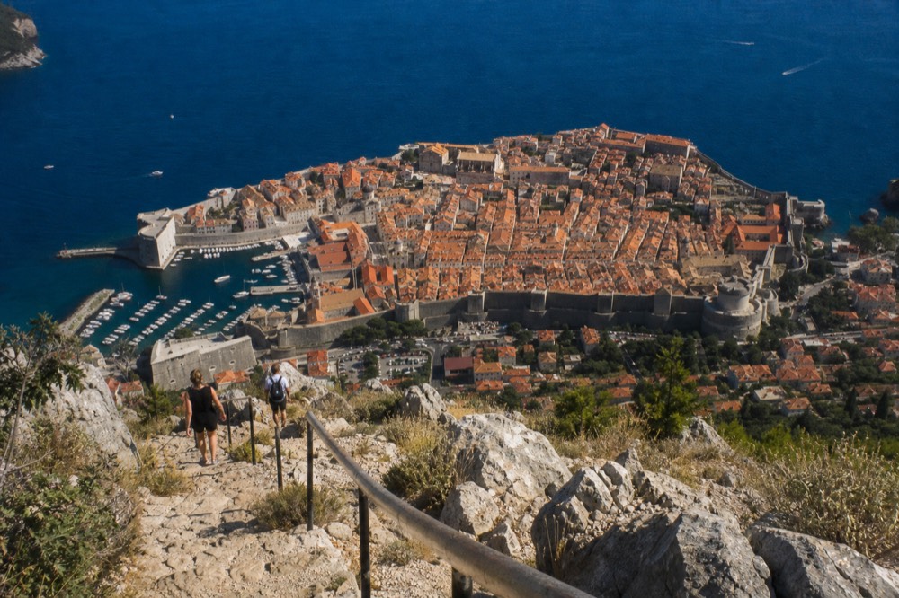 The city walls and orange rooftops of Dubrovnik filling the frame from a high vantage point on Mount Srd