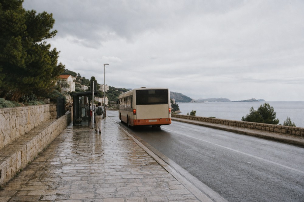 A local bus at a stop on a coastal road above the sea