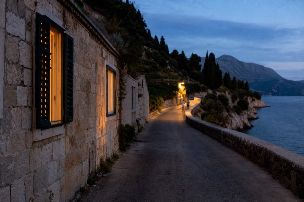 A coastal road winding along a peninsula with vineyards and the sea