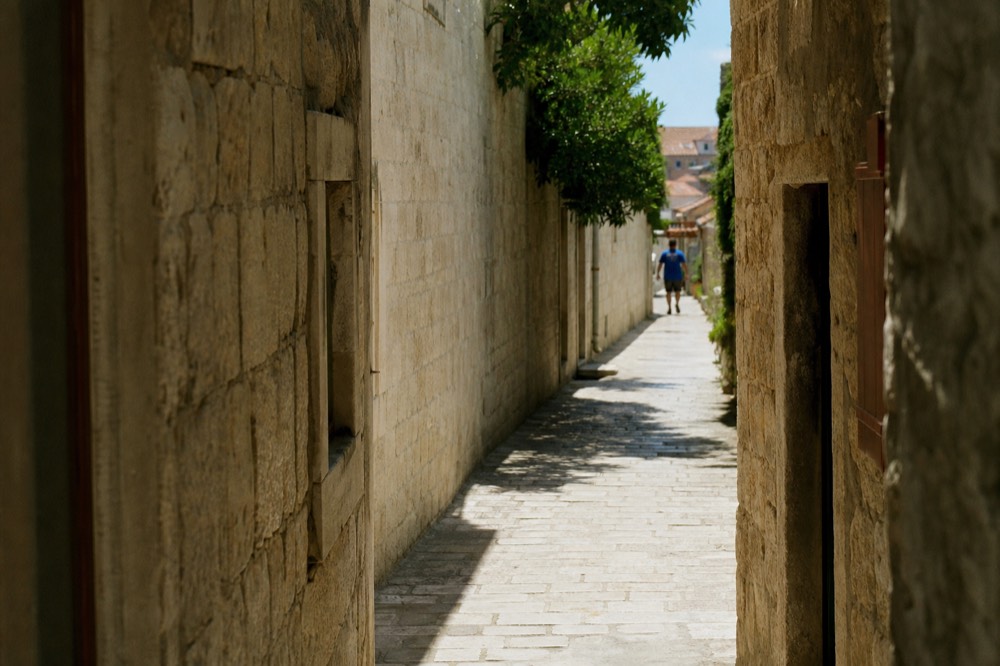A narrow stone street in the old town with sunlight on the paving