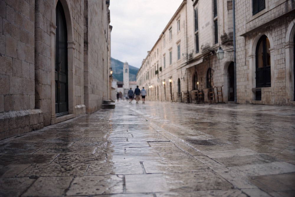 Limestone-paved main street of the old town lined by stone buildings in evening light