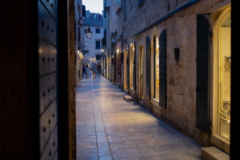 A narrow stone street in Dubrovnik lined with small boutique shopfronts