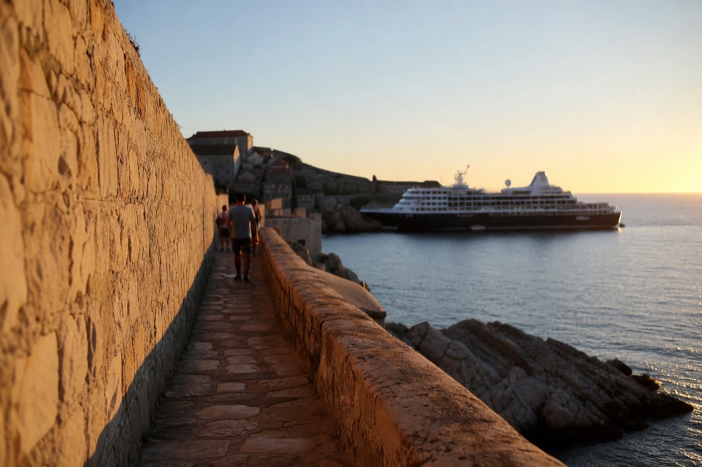 A cruise ship anchored outside Dubrovnik Old Town harbour at dusk