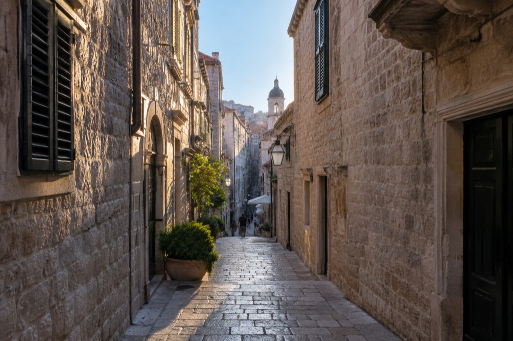 A narrow stone street in Dubrovnik Old Town with limestone paving in morning light
