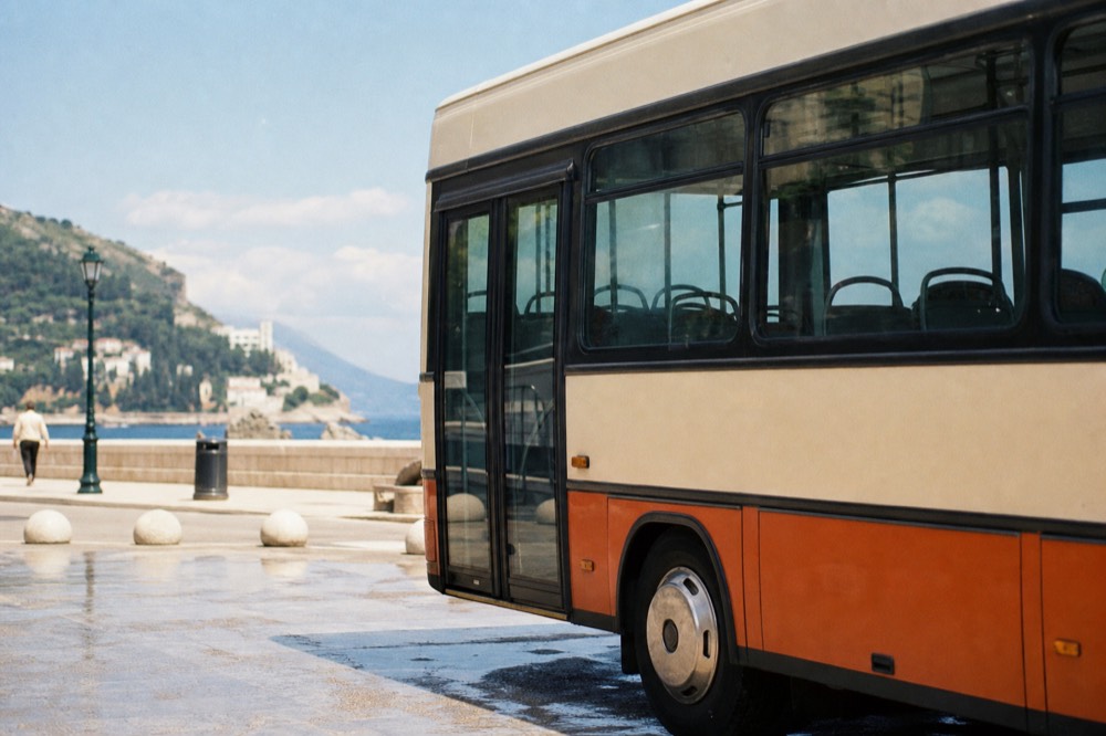 A local bus parked at a stop on a sunny street in Dubrovnik