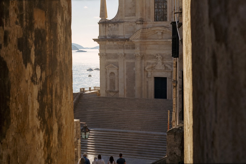 Broad baroque stone staircase rising toward a church facade