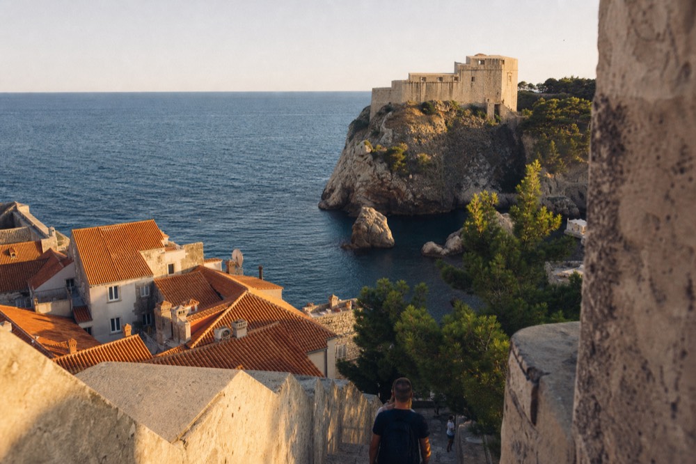 A stone fortress on a rock above the sea glowing in warm evening light