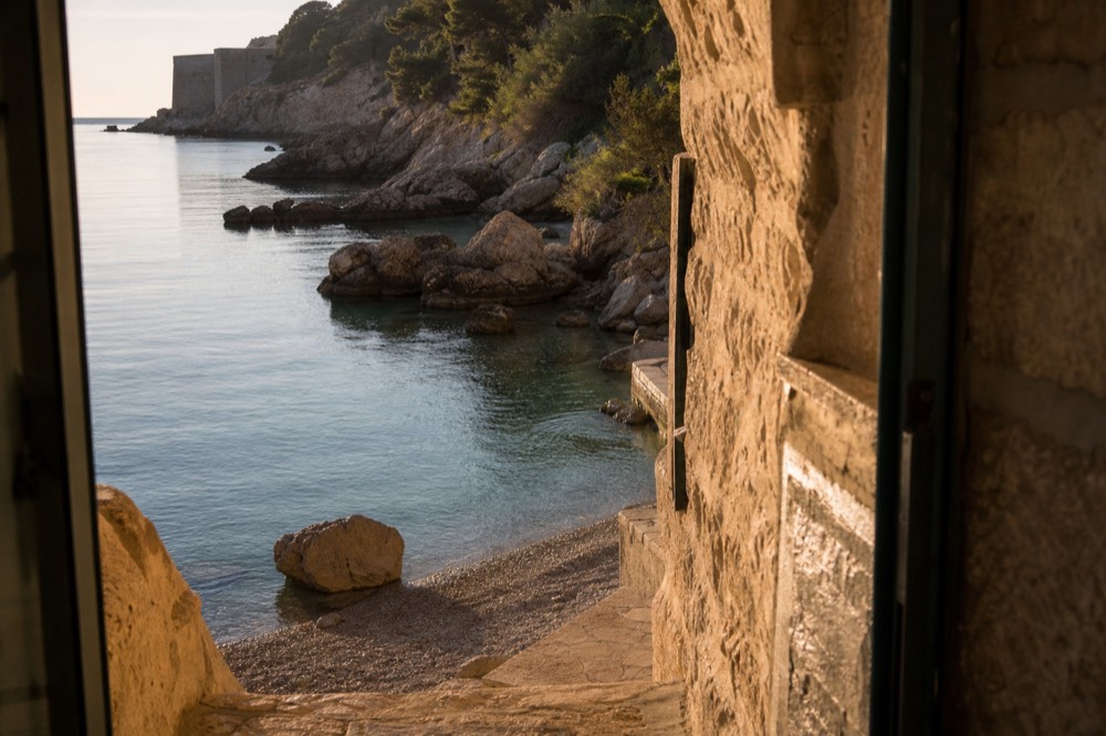 Calm glassy water in a cove in early morning light with nobody on the beach