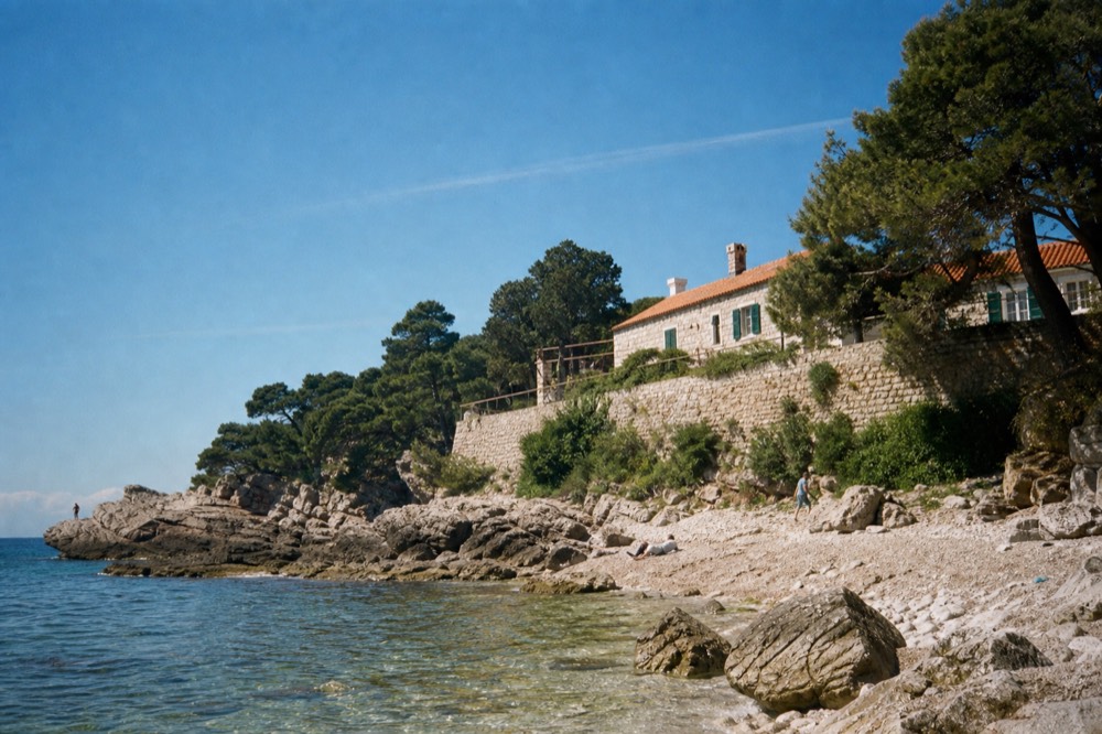 Rocky beach with calm clear water and pine trees near Dubrovnik