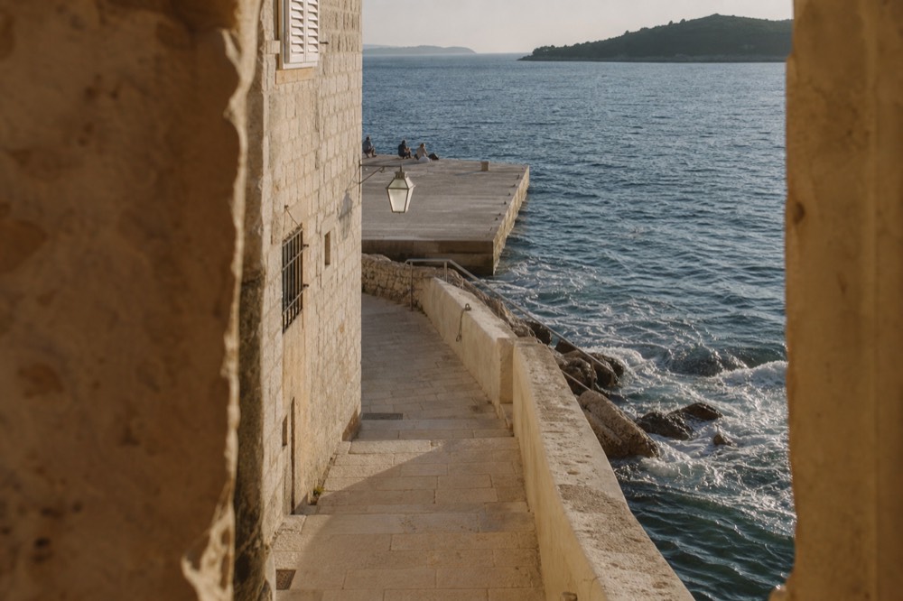 Sunlit Adriatic water with gentle waves near a stone quay