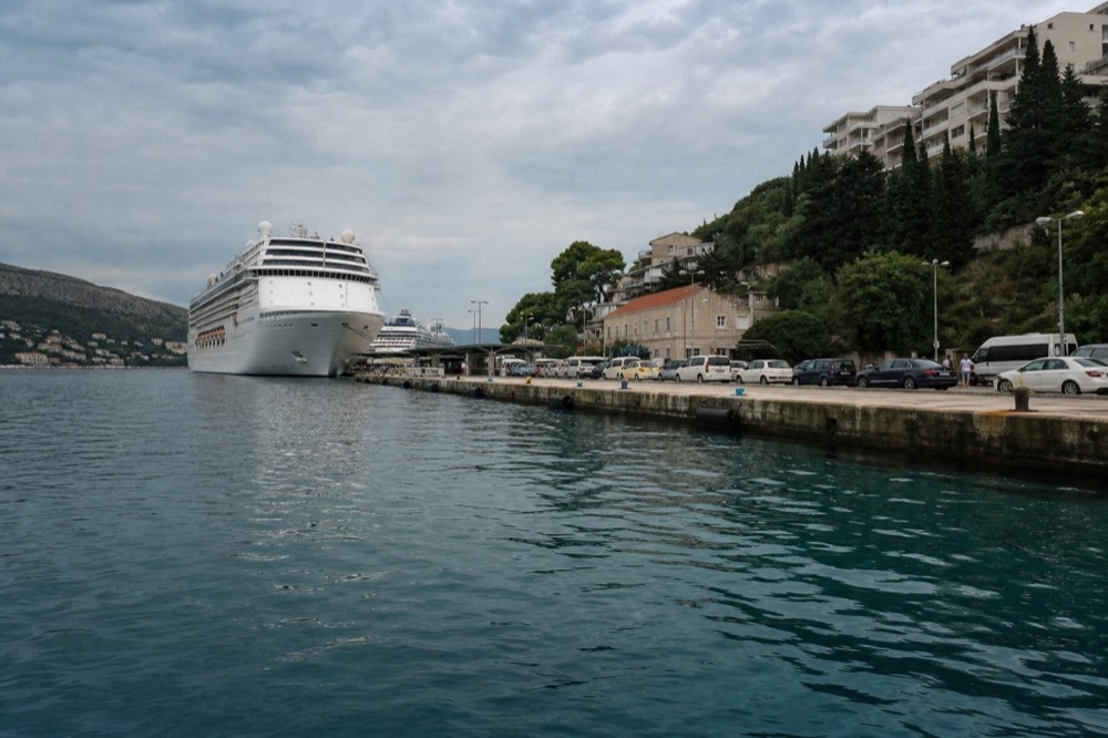 A cruise ship docked at Gruž port with taxis lined up on the quay