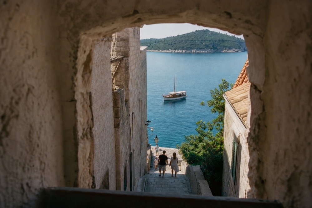 Wooden boat anchored in a calm turquoise bay beside a green island