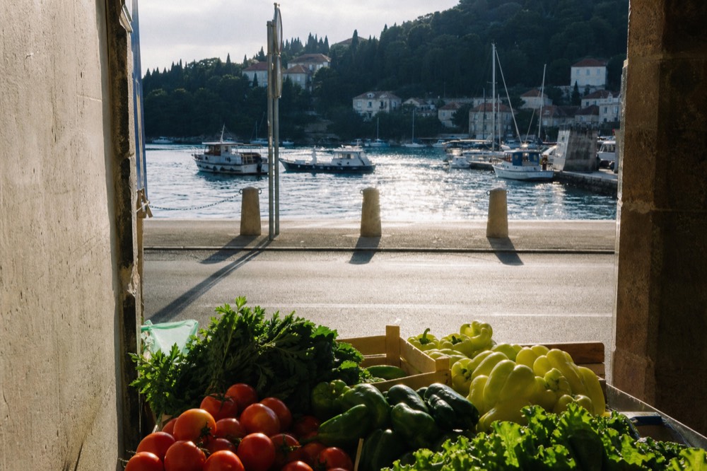 Fresh produce at the Gruž market, including tomatoes, peppers, and leafy greens.