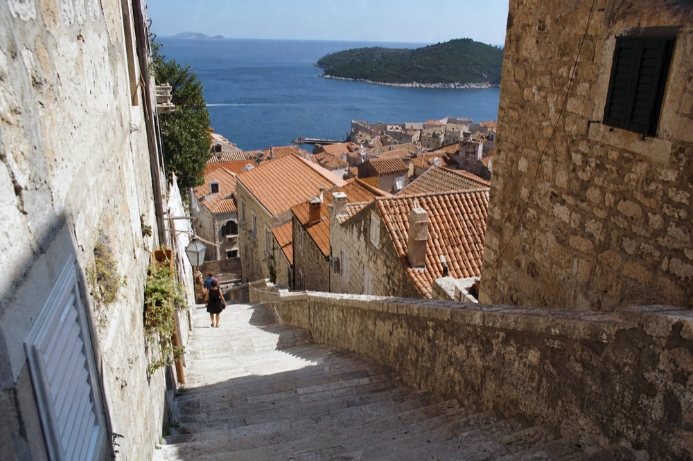 A broad stone staircase between tall houses in an old Mediterranean town
