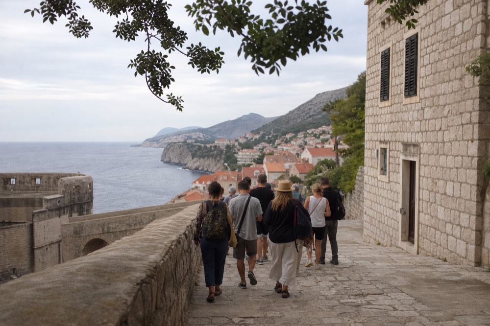 A guided walking group gathered on a stone street in Dubrovnik