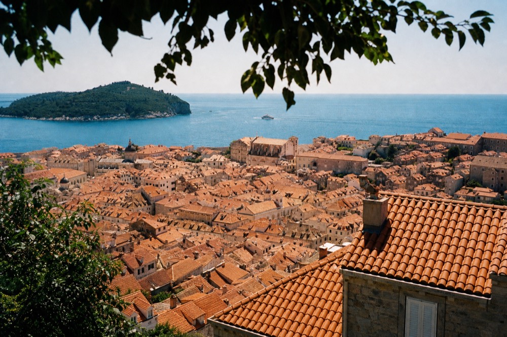A wide view over Dubrovnik rooftops with the sea beyond