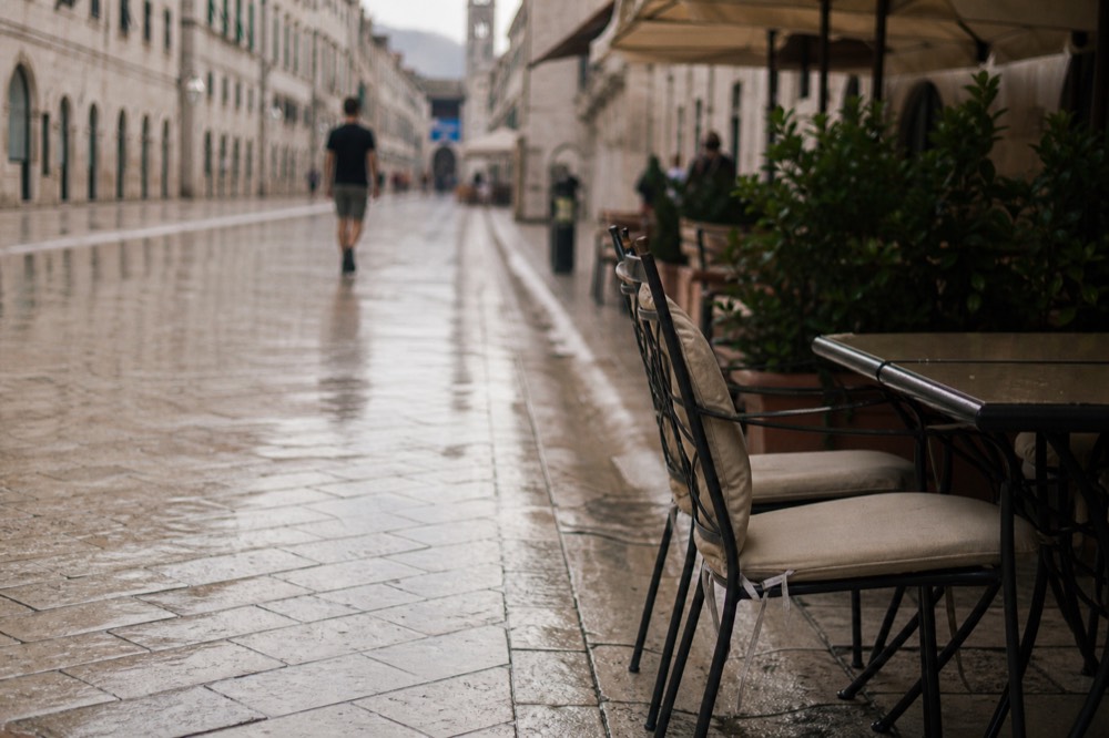 The wide stone-paved Stradun stretching through Dubrovnik Old Town with cafés along its edges