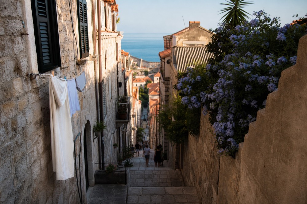 A narrow stepped stone street climbing between old houses in Dubrovnik Old Town