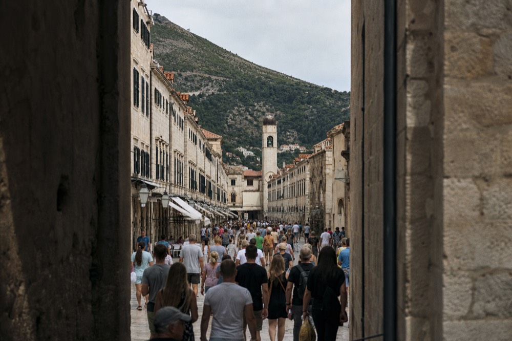 Crowds of pedestrians filling the Stradun in Dubrovnik Old Town at midday