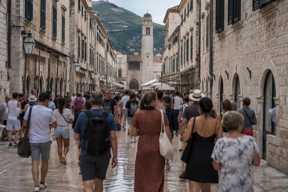 crowded limestone street in Dubrovnik with visitors walking between stone buildings