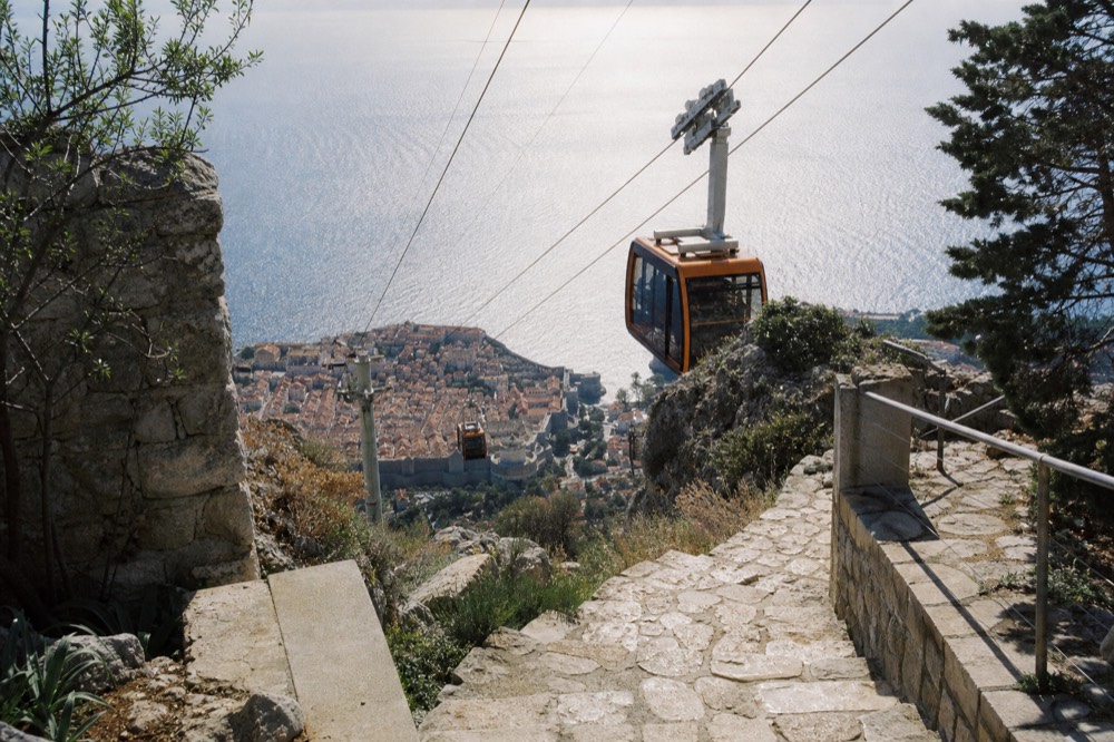 Cable car cabins climbing the hill above Dubrovnik toward Mount Srd
