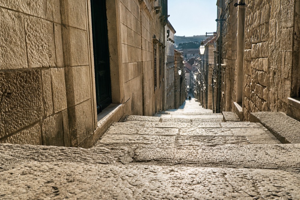 Empty limestone street in Dubrovnik old town in early morning light
