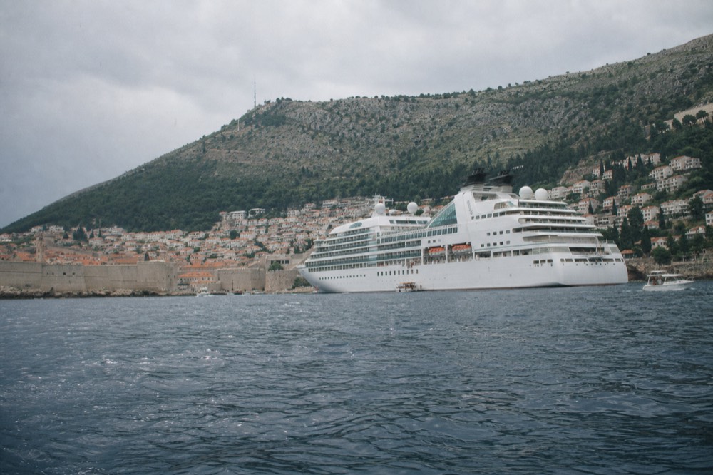 Cruise ship anchored in the bay with the walled Old Town behind it
