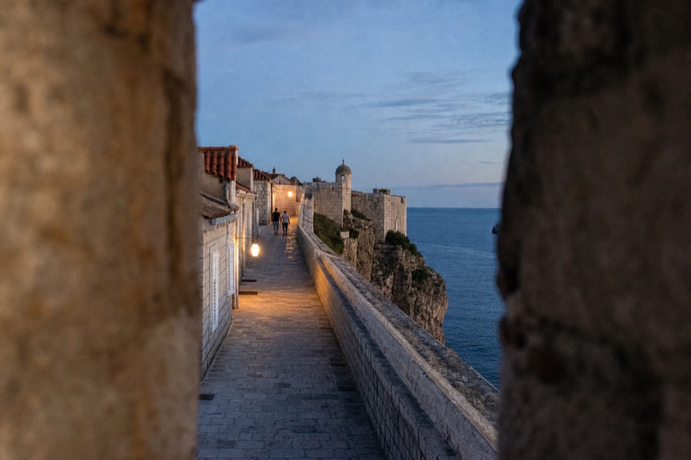 Stone walkway along the top of Dubrovnik's city walls with the Adriatic Sea on one side