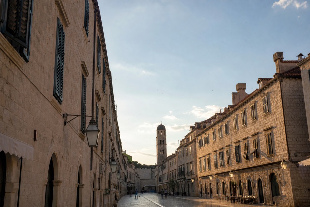 The limestone Stradun street stretching through the Old Town with shuttered buildings on both sides